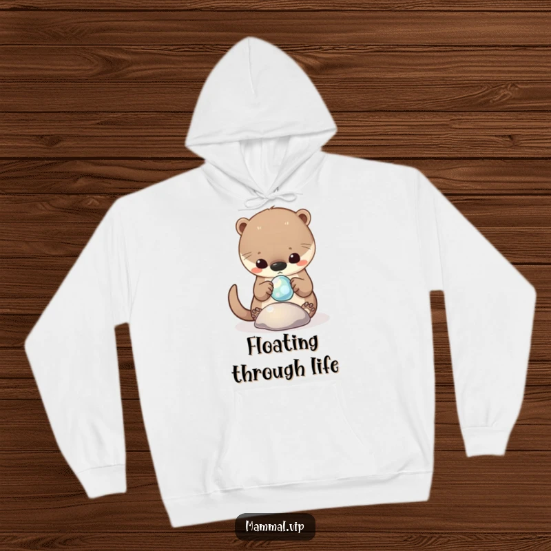 Funny Hoodie showing a curious otter character playing with a shiny, floating pebble, embodying carefree joy.